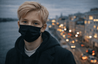 Мальчик в маске смотрит на камеру